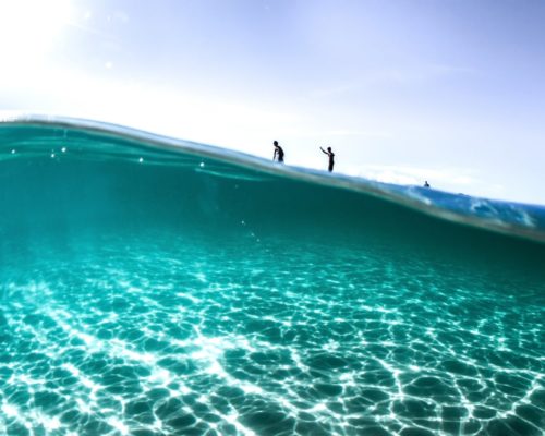 looking-underwater-to-surfers-on-wave